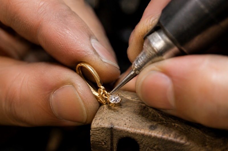 Artisan travaillant le fermoir d'une boucle d'oreille dormeuse