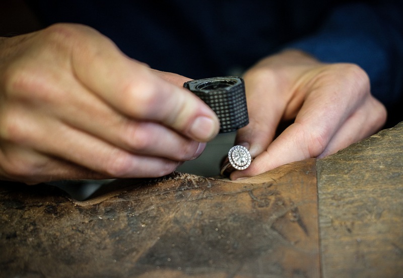 Expert Hauthentic travaillant sur le poli d'une bague de promesse en diamant