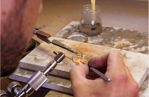 Artisan façonnant l'anneau d'un solitaire en diamant