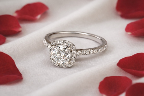 Bague avec halo sur diamant coussin et épaules pavées.