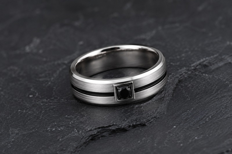 Bague en diamant pour homme présentant une rainure centrale en or blanc avec rhodiage noir ainsi qu'un diamant noir naturel traité.