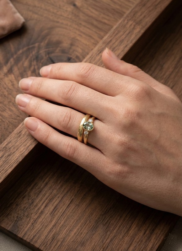 Femme portant une alliance et une bague de fiançailles en or jaune assorties.