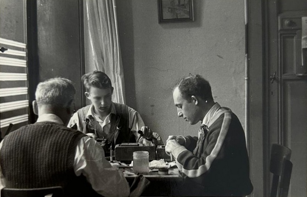 Léopold Beck (à gauche) et son frère Isaac Beck (à droite) expertisant des diamants avec leur père Israel Beck (de dos).