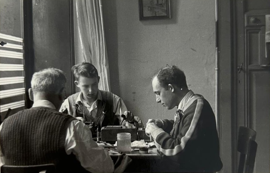 Léopold Beck (à gauche) et son frère Isaac Beck (à droite) expertisant des diamants avec leur père (de dos).