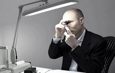 Expert Hauthentic observant un diamant à la loupe de diamantaire.