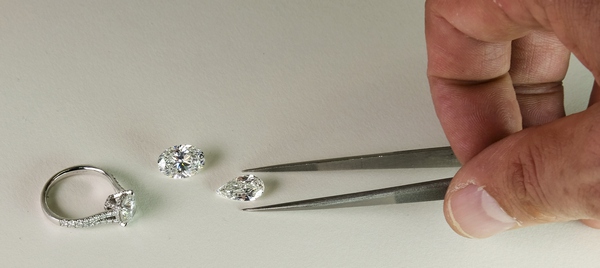 Expert hauthentic sélectionnant un diamant pour sertir une bague de fiançailles.